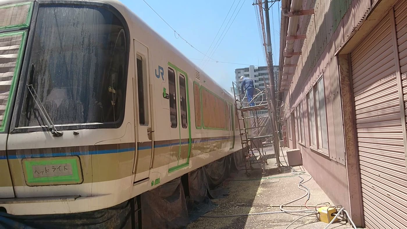 窓や表示部を養生した施工中の鉄道車両