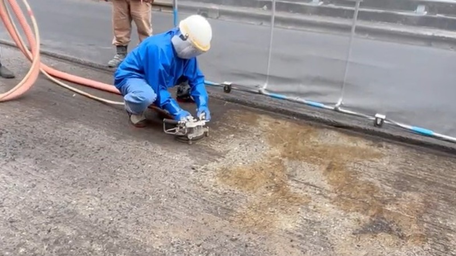 道路の路面をアクアブラストで表面処理し、古いプライマーを除去している様子